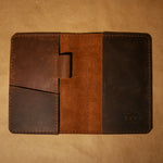 Brown leather field notes notebook cover with visible brand logo on a beige background