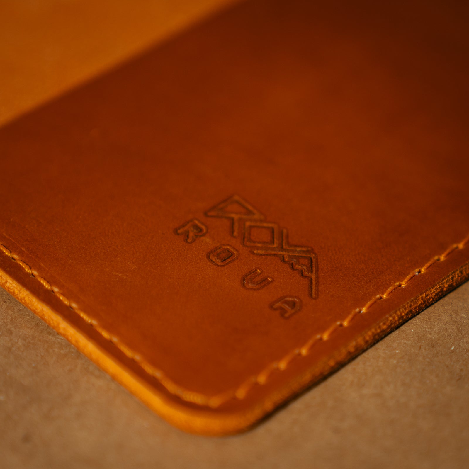 Close up of a whiskey orange leather field notes cover with branding.