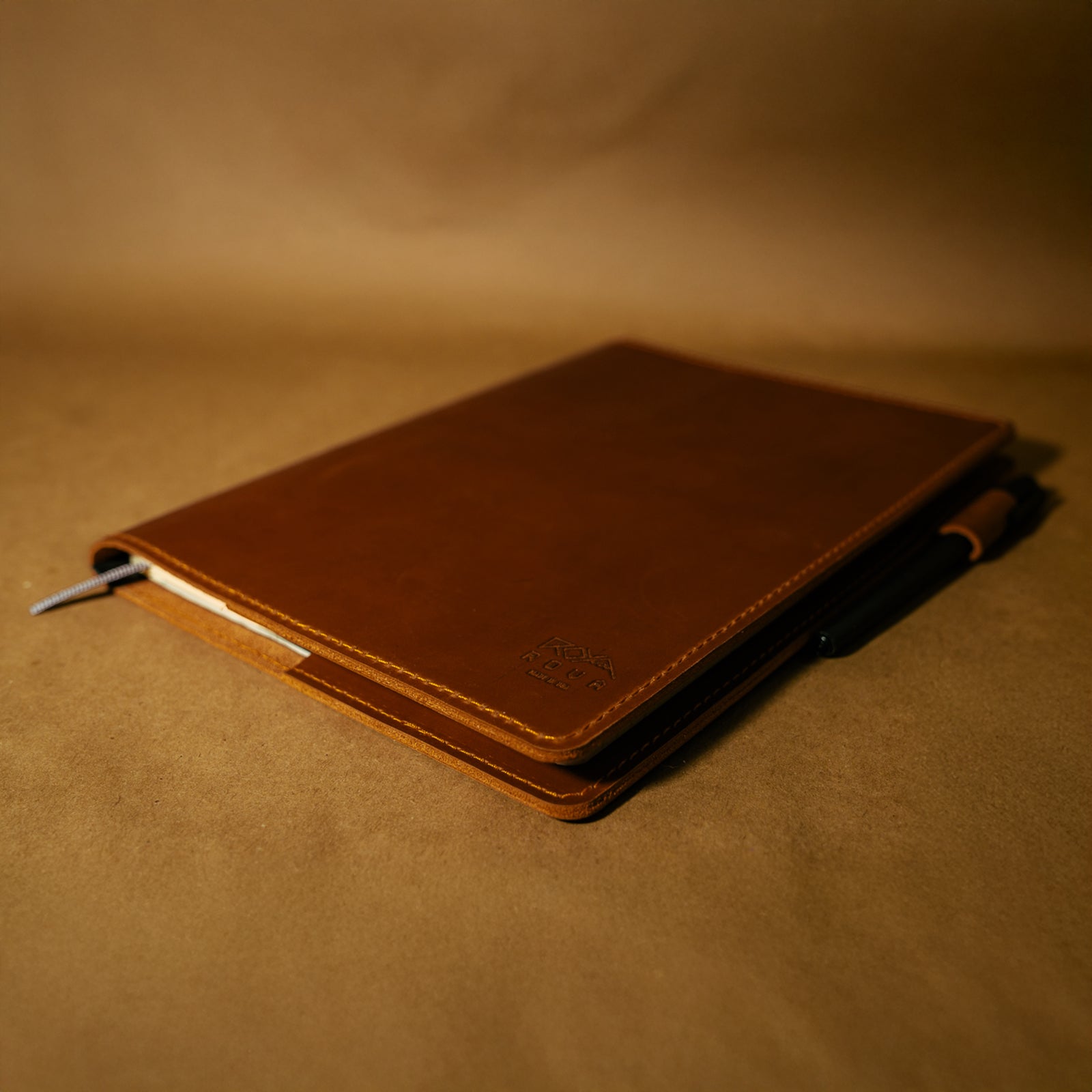 Brown full grain leather notebook cover on a matching brown background